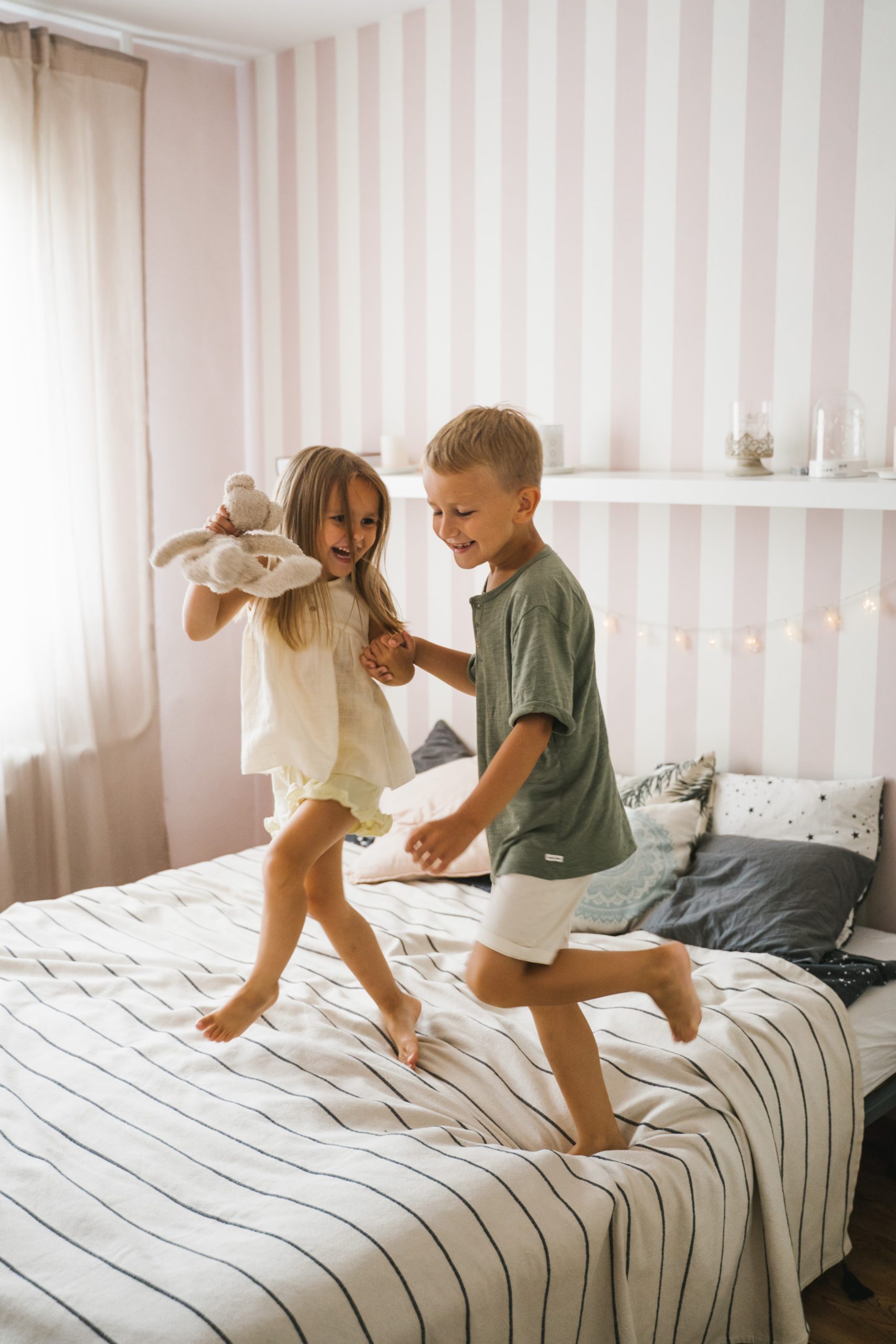 A girl and boy dancing on bed